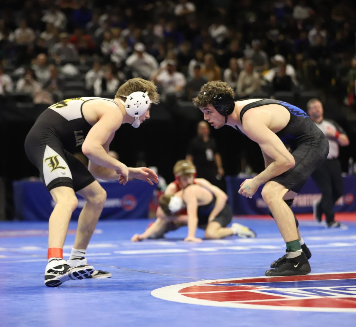 Looking at his opponent, junior Riley Sumner circles around the mat in the Class 4 boys wrestling semifinal in the 126 weight class. In the semifinal, Sumner lost by a 3-1 decision against senior Will Pfeifer of Liberty High School.