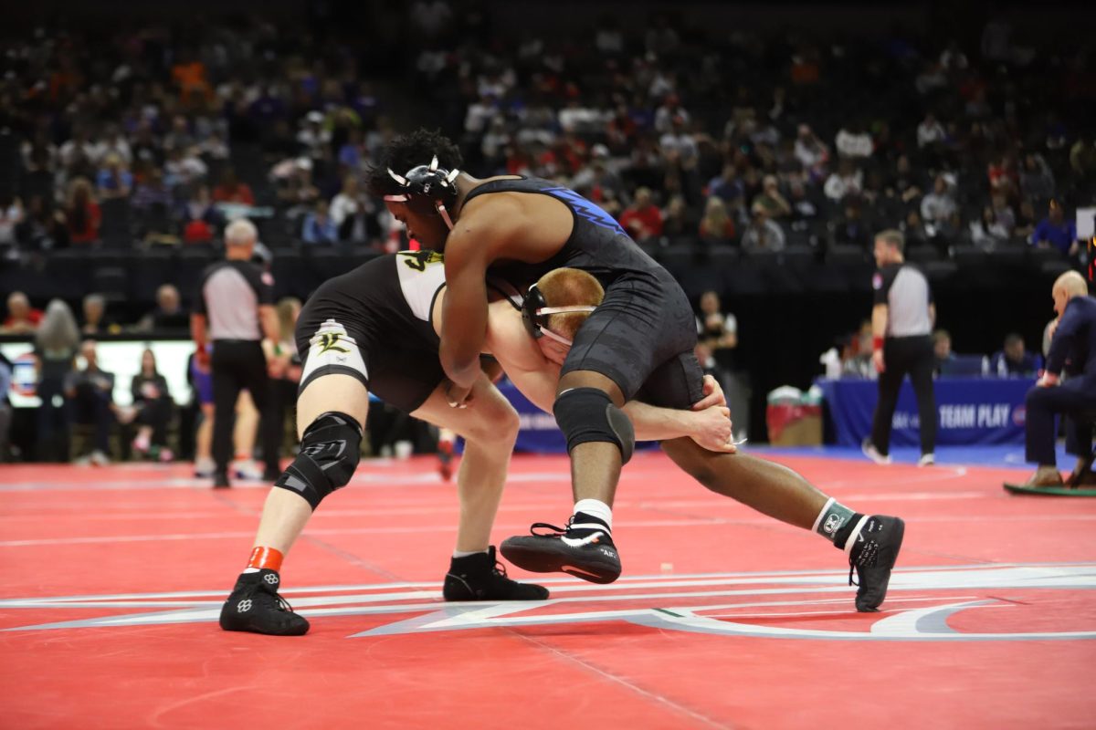During his semifinal match, senior Carter Welsh (175) grabs the leg of his opponent, senior Donovan Hodges of Liberty, Saturday, Feb. 28. Welsh's win earned him a spot to compete in the state final match. "My favorite part of the weekend was after my semifinal match: celebrating with my coaches, my family, and my teammates. Sharing that moment with the people who have supported me all season made it even better," Welsh said.