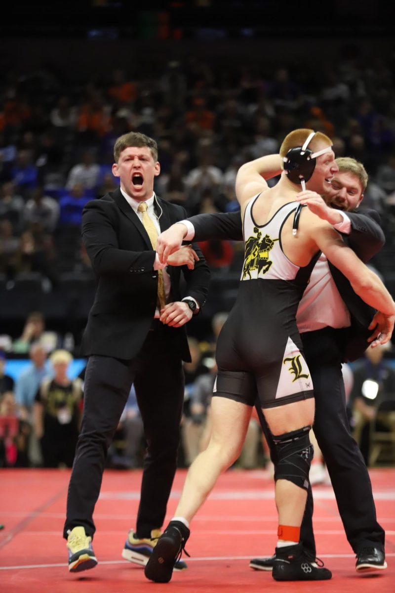 After his semifinal win in the 175 weight class, senior Carter Welsh and coach Sam Ritchie celebrate Welsh's advancement to the state final. "My favorite part of the weekend was after my semifinal match," Welsh said. "Celebrating with my coaches, my family, and my teammates [and] sharing that moment with the people who have supported me all season made it even better."