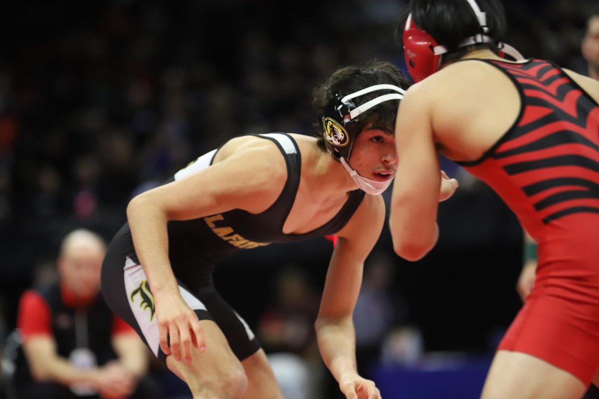 Facing freshman Taiga Kwon of Ozark High School, junior Max Rowe fixes his attention on his opponent at the start of their bout. Rowe placed third in the 113 weight class in Class 4 of boys wrestling. "I've only been wrestling for four years and [even getting] fifth place last year was a big accomplishment," Rowe said.