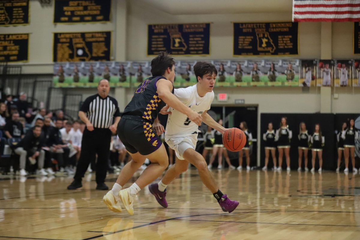In the Battle of 109, junior Ryan Rolwing dribbles past a Eureka defender. The Lancers lost to the Wildcats, 56-53, but Rolwing led the team with 11 points.