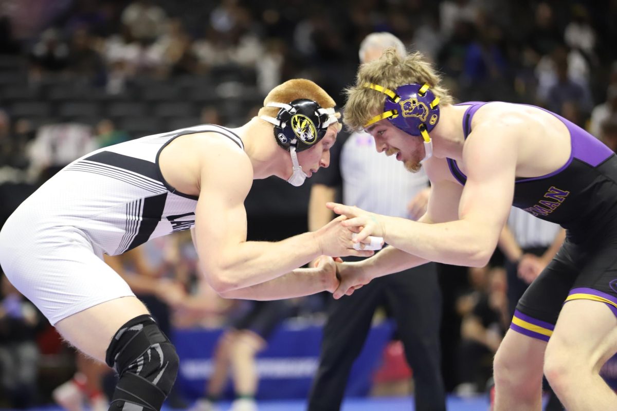 In the boys Class 4 state championship in the 175 weight class, senior Carter Welsh begins to lock hands with junior Luke Hayden of Hickman High School during their bout. Welsh placed second in his weight class after a loss by 4-2 decision against Hayden. "Before my quarterfinal match, my coaches helped me realize that as the 'underdog,' the pressure really wasn't on me. It was on everyone else," Welsh said. "That helped me wrestle more free and just focus on competing my best."