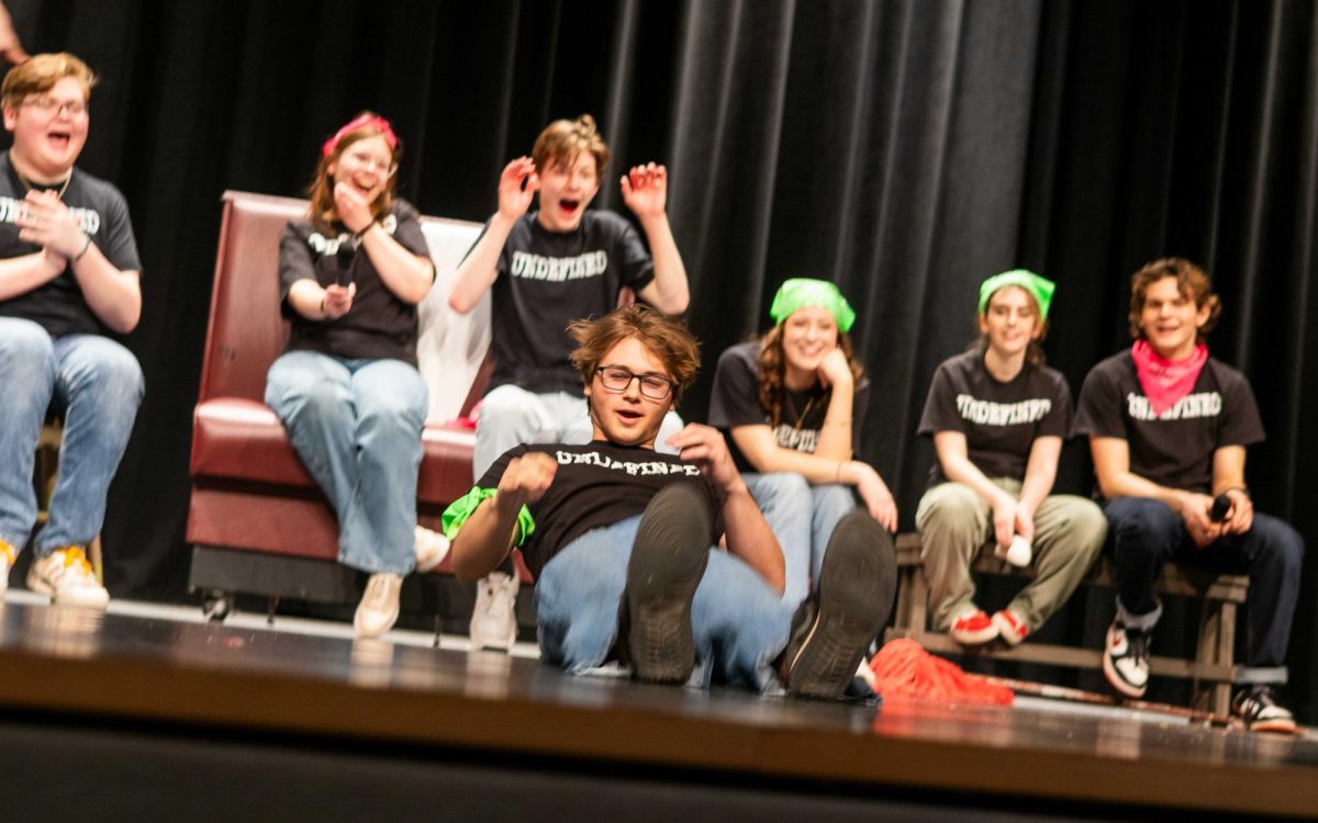 Senior Chase Suttmueller sits in an invisible chair for a game of Commercials and falls onto the stage. "In general I’d say [improv] is always fun to do even if you're not funny all the time," Suttmueller said.

