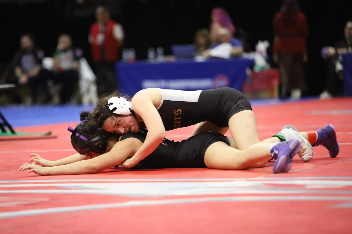 After choosing to start the second period on top, senior Rory Flores (115) continues to lay on top of her opponent to prevent an escape. Flores lost in sudden victory by a 3-0 decision against sophomore Avery Edwards of Lee's Summit North High School.