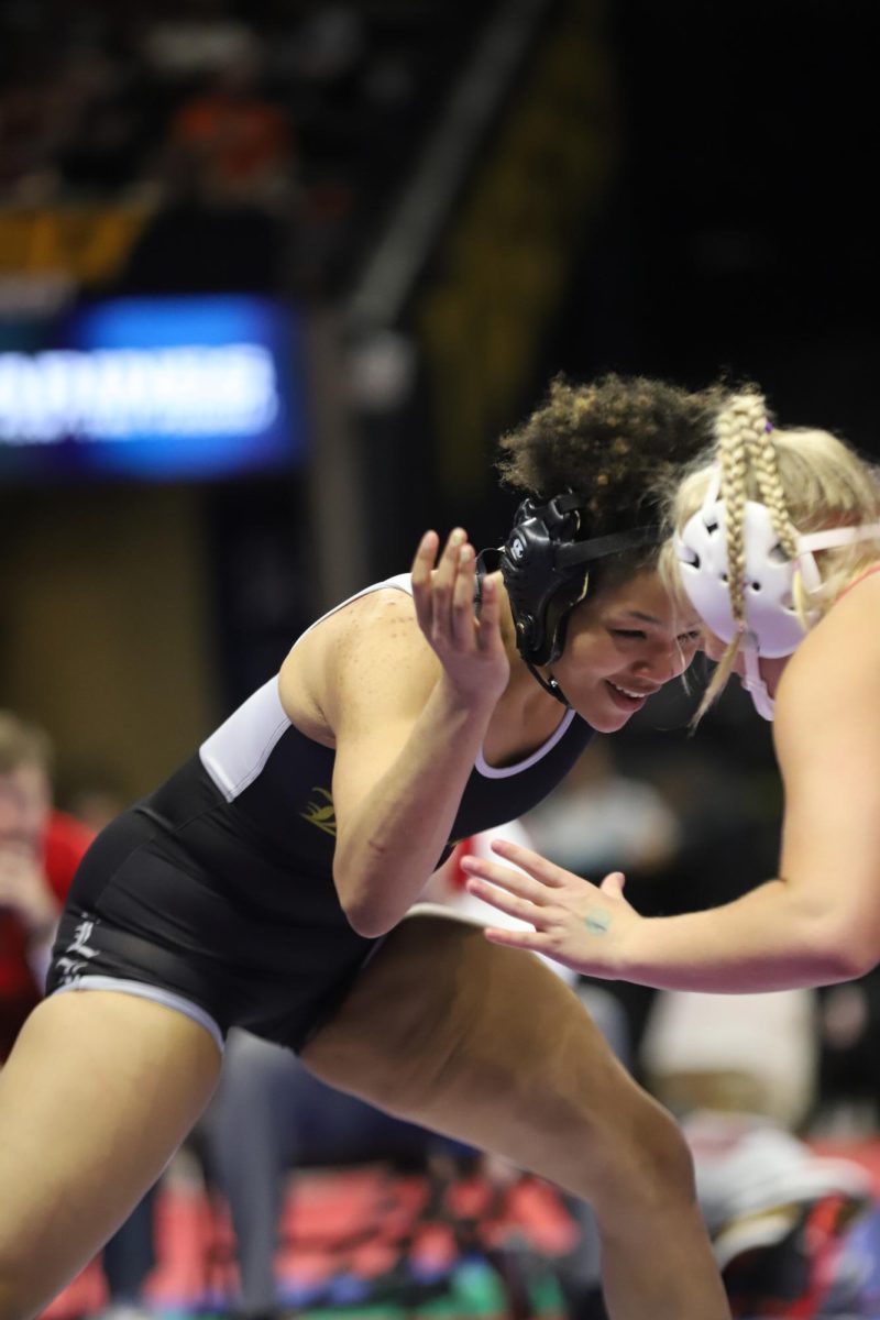 While smiling, senior Ella Kimbrough wrestles senior Natalie Edmisson of Nixa High School in the 155 weight class semifinal. Kimbrough lost the semifinal by fall but was able to wrestle back and place third in her weight class.