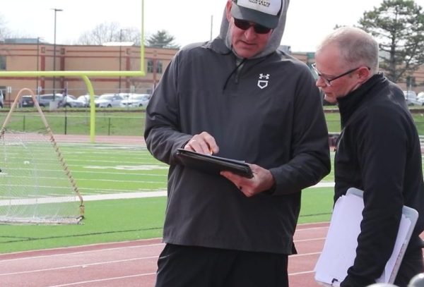 Boys Head Track Coach Scott Haxton discusses team details with fellow coaches.
