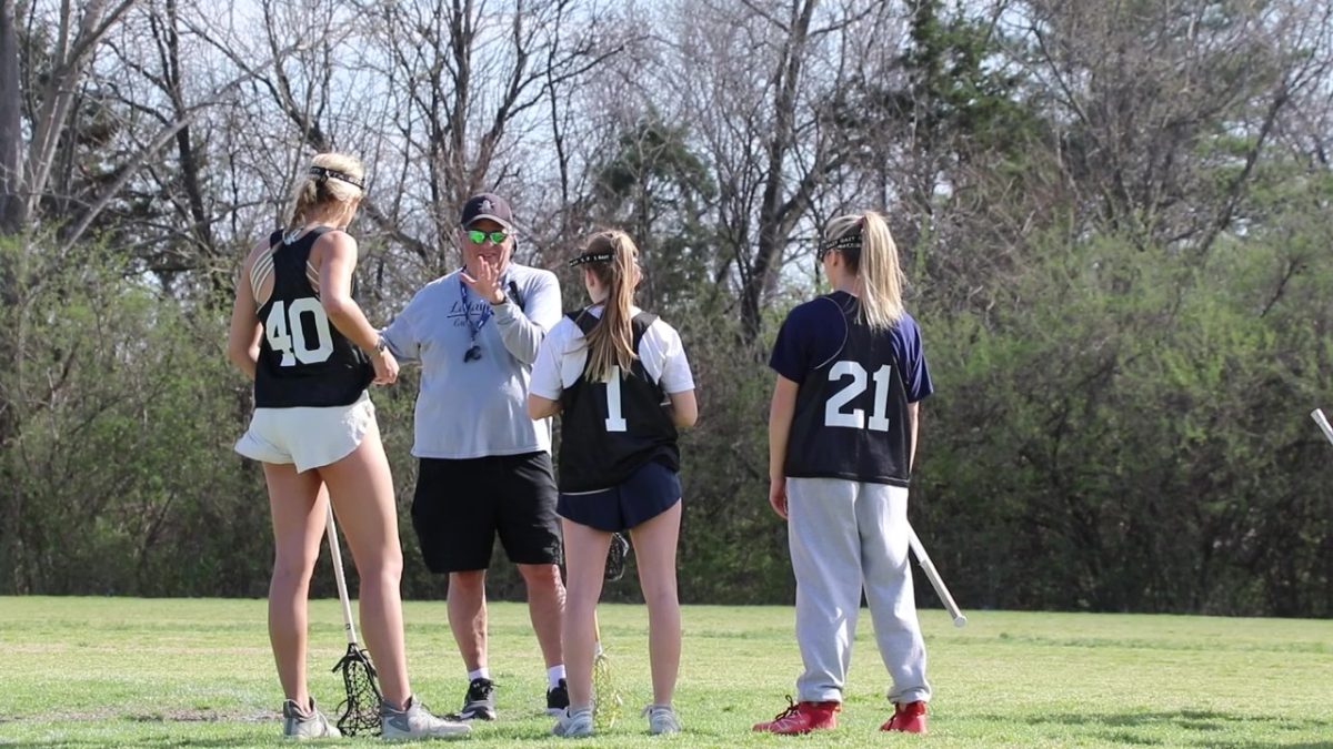 Coach, Keith Brisotti, disusses gameplay with players, Julia Kottke, Rhianyn McIntyre, and Lucy Carroll.