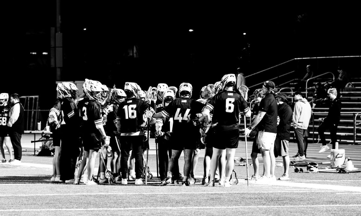 Lacrosse players huddle before their game  in order to plan their attack and defense.