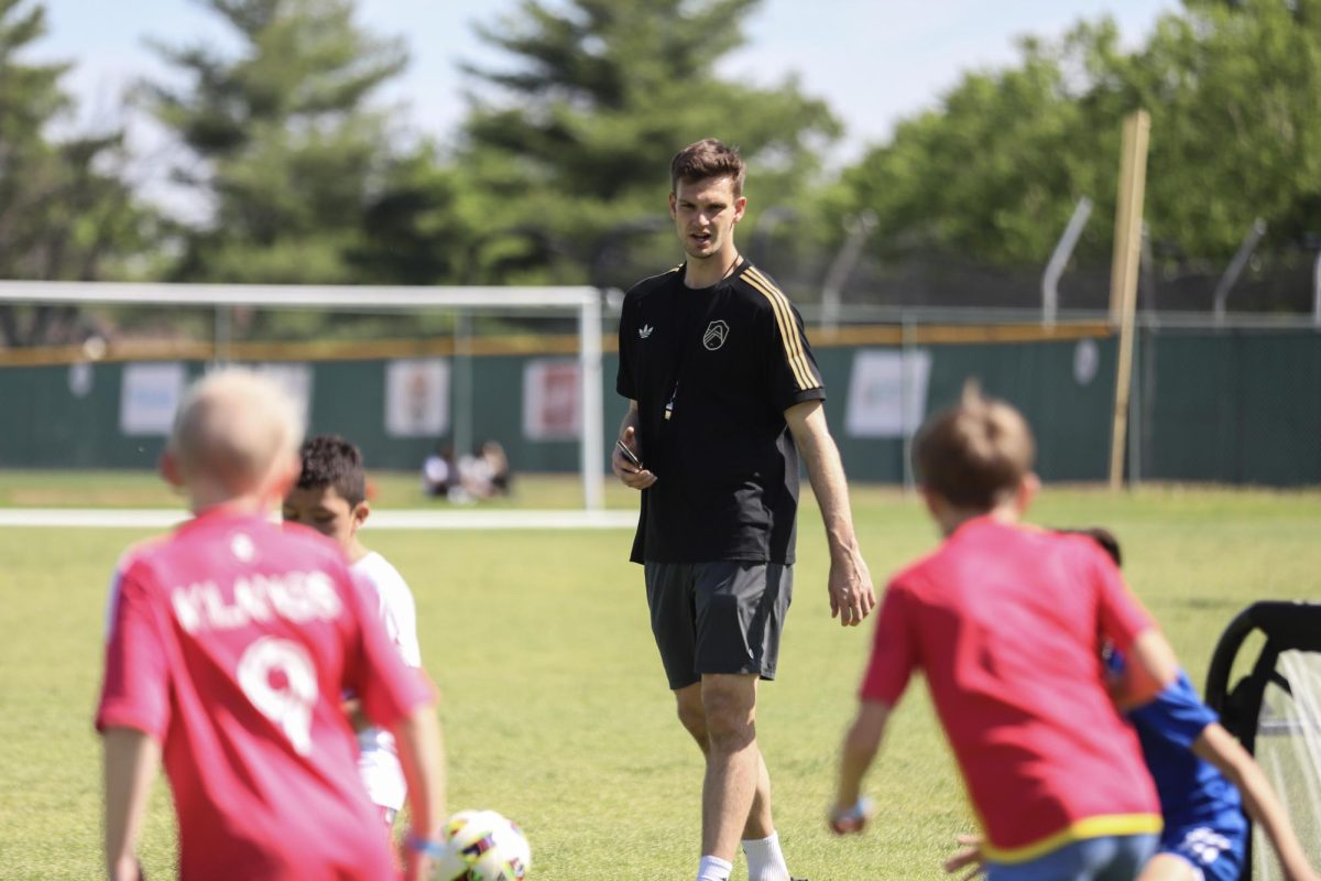 Watching a small group scrimmage, Ben Lundt, St. Louis City SC goalkeeper and founder of Lundt Pro Soccer Training, shouts words of encouragement to players on Sunday, April 26 n the Lafayette grass soccer field. “The idea behind [the event] was to bring the professional soccer players closer to the community because usually people only get to see us on TV or in the stadium. [Families] actually having the opportunity to have their kids on the field with us is the most important aspect,” Ben Lundt said.